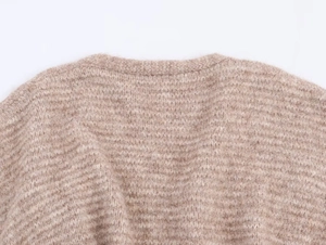 Detailaufnahme des gerippten Ausschnitts an einer beigen Strickjacke mit weicher Textur