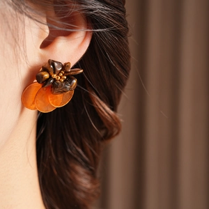 Detailed view of vintage flower earrings with brown beads and translucent amber petals