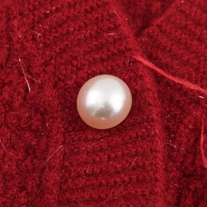 Detailed view of red mohair knit cardigan featuring a luxury oversized pearl button