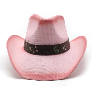 Detailed view of pink woven cowboy hat with floral embroidery and metal studs on band