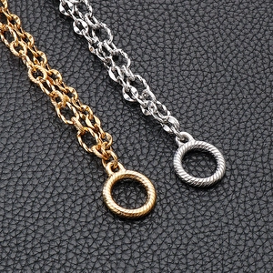 Macro view of gold and silver stainless steel 304 chains with detailed OT buckle on leather