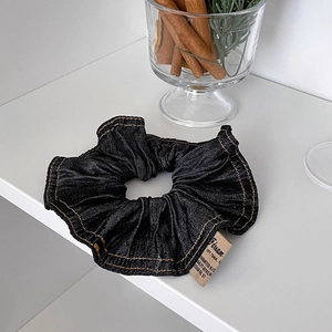 Navy blue denim scrunchie with contrast stitching and authentic paper brand tag