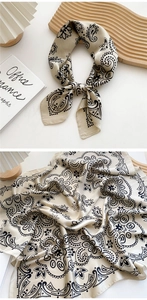 Close-up of beige paisley silk scarf with bohemian patterns and smooth satin texture