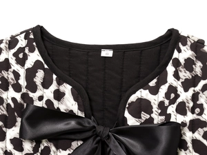Detail of animal print vest featuring quilted texture and large black satin bow tie