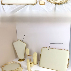 Detail of gold metal jewelry stands with cream microfiber padding for necklaces and rings
