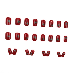 24-piece set of short red glossy press-on nails with green star patterns on white background