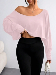 Front detail of pink off-the-shoulder crop top featuring a relaxed fit and long sleeves