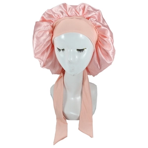 Pink satin sleep bonnet featuring wide elastic band and long decorative ribbon ties