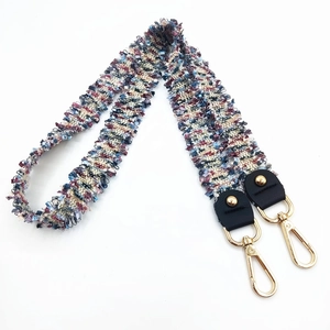 Macro view of woven tweed replacement shoulder strap with gold metal lobster clasps