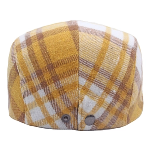 Macro shot of British style plaid wool cap with metal buckle details and woven texture
