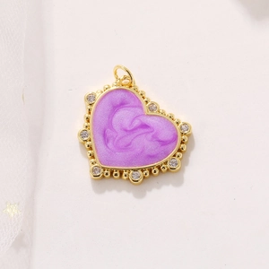 Colgante corazón chapado en oro con resina púrpura y circonitas en fondo blanco