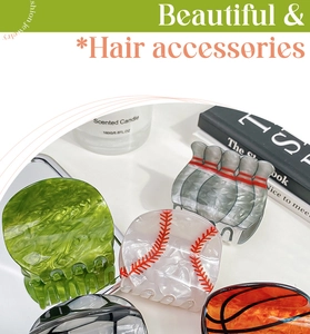 Detail showing sports-themed hair claws with baseball, basketball, and marble patterns