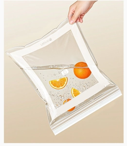 Detail of leak-proof clear food storage bag holding water and orange slices