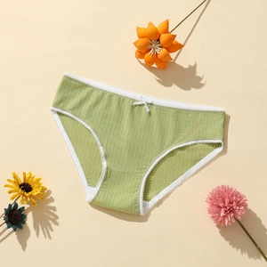 Green ribbed polyester panties for women with white lace trim and bow on beige background