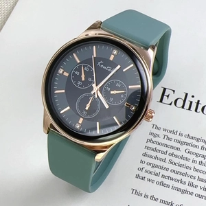 Detail shot of rose gold watch case with morandi green silicone strap on a magazine background