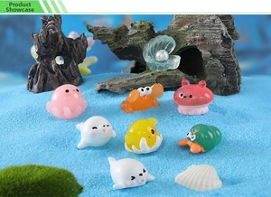 Miniature ocean animal figurines including octopus and crab on blue decorative sand