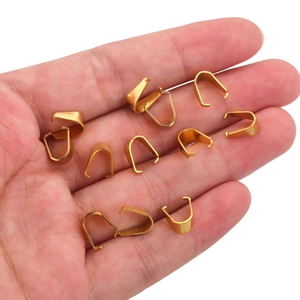 Golden stainless steel pinch bails for pendant necklaces shown in hand for scale