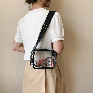 Transparent PVC crossbody bag with wide black strap and colorful silk scarf detail
