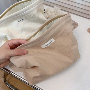 Detail of striped cotton pouch with simple wish label and smooth zipper closure