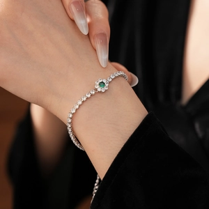 Detail of silver zircon bracelet with green flower gemstone on a model wrist