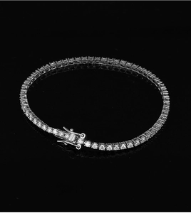 Macro shot of silver tennis bracelet with moissanite stones on black reflective surface