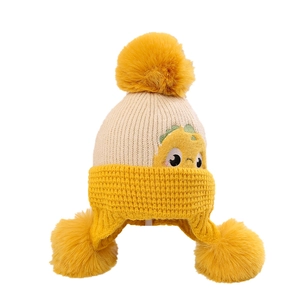 Winter knit child hat with earflaps, dinosaur embroidery, and large faux fur pom-poms