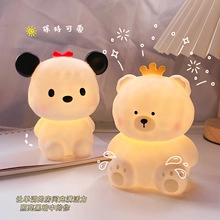 Close-up of cute bear silicone night lights with warm glow on a wooden desk