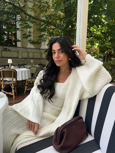 Dreiteiliges weißes Strickset mit Zopfstrickjacke und passendem Rock im Freien