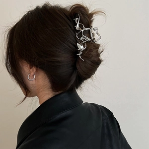 Detail of silver liquid metal hair claw clip worn on hair bun with a modern aesthetic