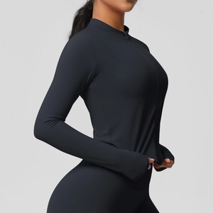 Détail de la veste de yoga noire ajustée avec des passe-pouces pratiques et une fermeture éclair