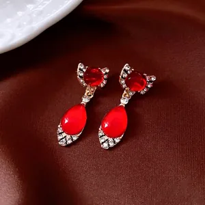 Vintage waterdrop jewelry set with red stones and diamonds on gold metal and brown silk