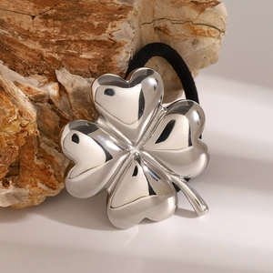 Silver mirror clover hair tie with black elastic band on natural stone background