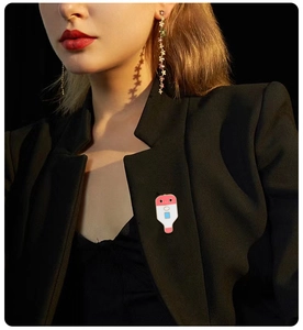 Detail of colorful enamel thermometer brooch pinned on a medical lab coat lapel