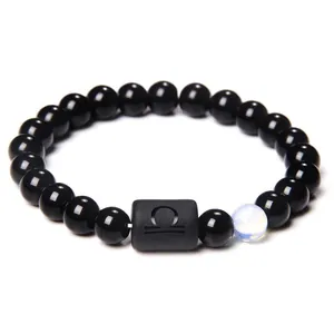 Detailed macro of Libra obsidian bracelet featuring matte zodiac bead and luminous stone