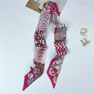 Detail of silk scarf with pink and gold geometric motifs and elegant feather patterns