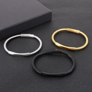 Dettaglio di bracciali con catena a serpente flessibile in argento, oro e nero acciaio inox