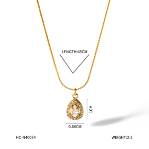 Macro detail of 18K gold stainless steel necklace with waterdrop pendant and clear crystal