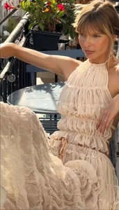 Detail of cream-colored halter top and tiered ruffle maxi skirt with drawstring waist