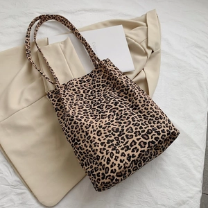 Flat lay of vintage leopard print canvas tote bag with dual handles on neutral backdrop