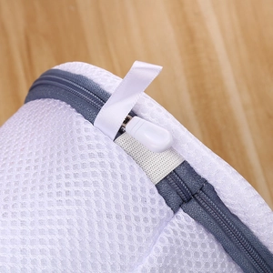 Detail shot of the white mesh laundry bag showing the gray zipper and protective cover