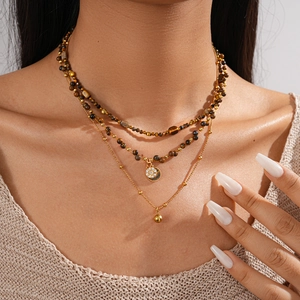 Close-up of triple-layer 18k gold plated necklace with tiger eye beads and pavé pendant