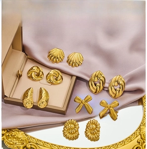 Set of six gold bow and textured knot stud earrings displayed on elegant satin fabric