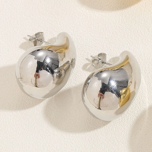 Macro shot of silver teardrop stud earrings with a high-polished mirror finish