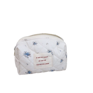Trousse à cosmétiques matelassée en coton avec motif floral bleu et étiquette décorative