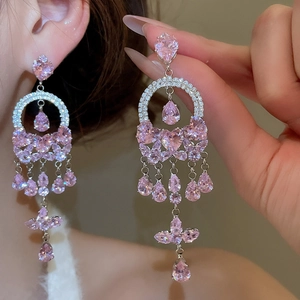 Close-up of pink zircon butterfly tassel earrings worn for a luxury fashion look