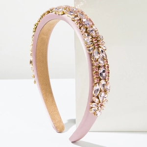 Gros plan détaillé du serre-tête en satin rose avec des motifs de fleurs en strass
