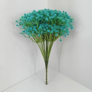 Detail of teal artificial baby's breath bouquet with green stems and white wall background