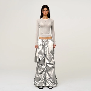 Futuristic silver coated cargo pants with a grey slim-fit knit top on a fashion model