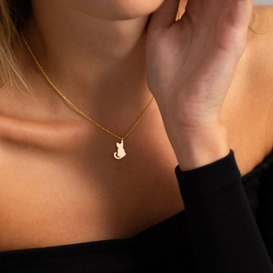Vue détaillée d'un pendentif silhouette de chat en plaqué or 18K sur une chaîne délicate