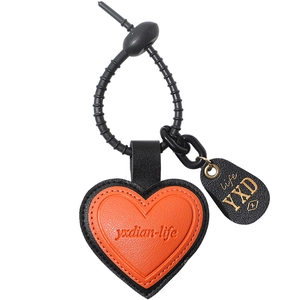 Minimalist orange and black leather heart keychain with textured strap for handbag decor